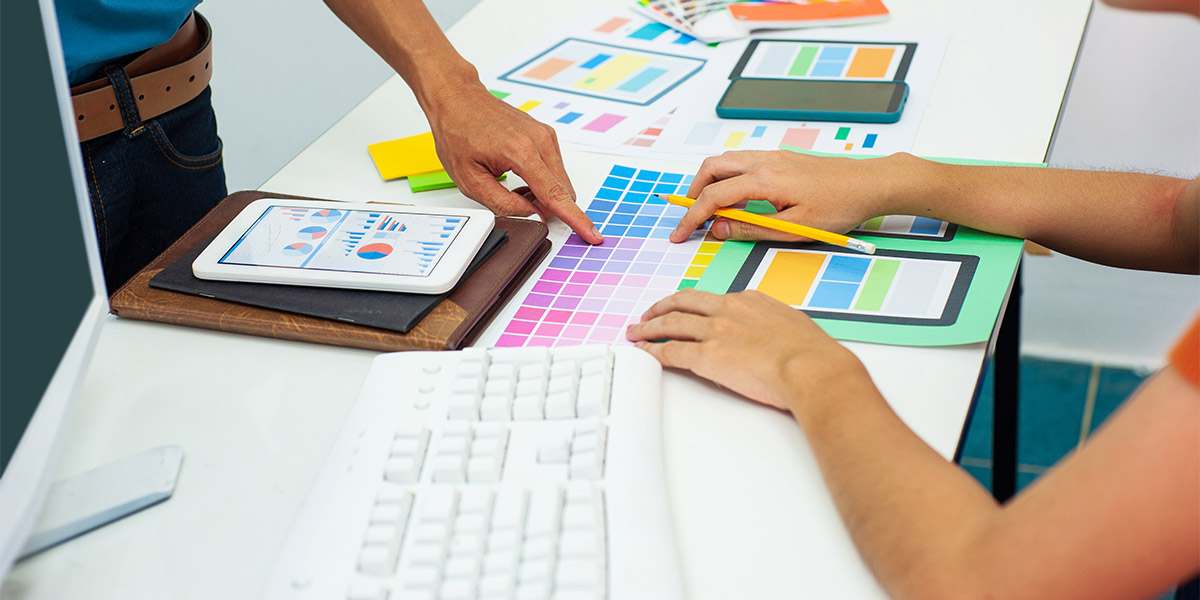 Designers are designing colors of mobile app layouts.