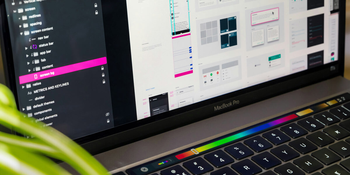 A laptop featuring a colorful display, positioned alongside a potted plant for added visual interest.